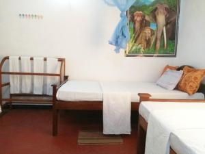Zimmer mit 2 Betten und Wandgemälde in der Unterkunft Pawansa Home Stay in Habarana
