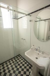 a bathroom with a sink and a mirror and a checkered floor at Helensburgh Hotel in Helensburgh