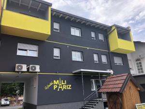 a building with a mill park sign on the side of it at Hostel Mali Pariz in Slavonski Brod