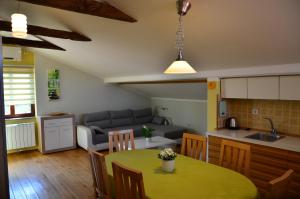 a kitchen and living room with a table and a couch at Apartma Louis in Dutovlje