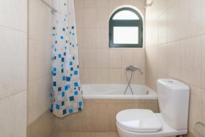 a bathroom with a toilet and a bath tub at Allegro Studios & Apartments in Marathias