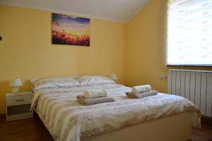 1 dormitorio con 1 cama con 2 toallas en Apartma Louis, en Dutovlje