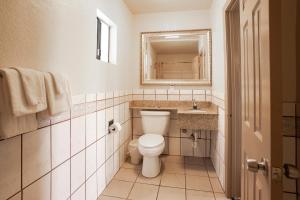 a bathroom with a toilet and a sink and a mirror at Economy Inn Hollywood in Los Angeles