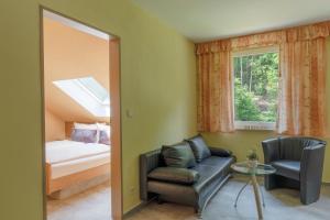 Habitación con sofá, cama y ventana en Luckai Hotel & Restaurant Inhaber Dennis Burmann, en Freienohl