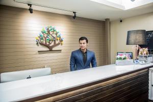 a man standing behind a counter in a waiting room at Khaosan Park Resort in Bangkok