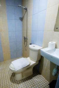 a bathroom with a toilet and a sink at Arya Inn in Pematangsiantar