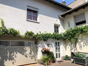 ein weißes Haus mit einer Garage mit Blumen darauf in der Unterkunft Darmstädter Hof in Mainz