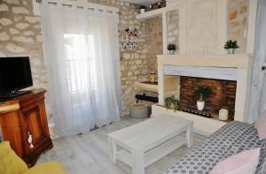 a living room with a couch and a fireplace at Au mazet de Carmélina in Paradou
