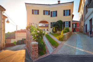 a house with a brick wall and a street at La Dolce Vite in Tonco