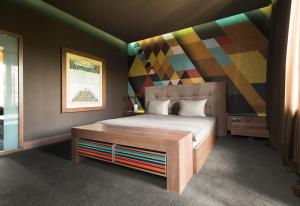 a bedroom with a bed with a colorful wall at Mimi Hotel Chisinau Jolly Alon in Chişinău