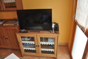 Apartamento en Isaba (NAVARRA) في إيسابا: تلفزيون بشاشة مسطحة على منصة خشبية في الغرفة