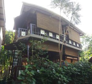 a building with a balcony on the side of it at T Star Cottage Langkawi in Pantai Cenang