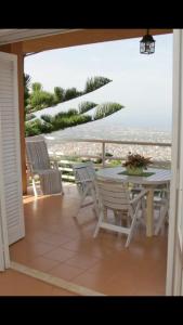 un patio con mesa y sillas y vistas al océano en Lomarchi Holiday Home en Carini