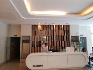 un homme debout à un comptoir dans un hall dans l'établissement Stay Amare Green La Salle Taft, à Manille