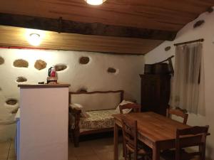 a kitchen and dining room with a table and a couch at Caseddu di Chjarastella in Figari