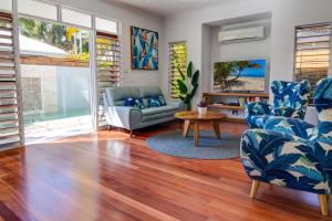 - un salon avec des chaises bleues et une table dans l'établissement Hanalei Port Douglas - Private Pool, à Port Douglas