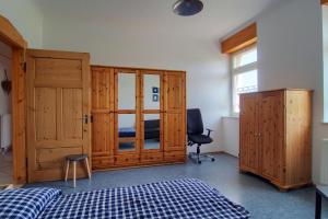 um quarto com armários de madeira, uma cama e uma cadeira em Ferienwohnung Renchglück em Renchen