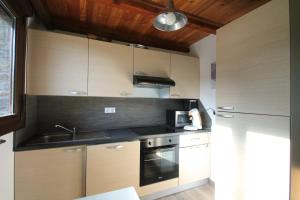 a kitchen with wooden cabinets and a stove top oven at Llorts, Casa Rustica, Ordino, Zona Vallnord in Llorts