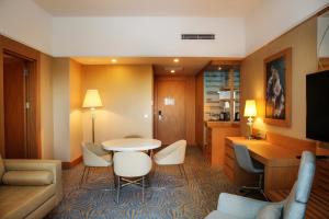 um quarto de hotel com uma mesa e cadeiras em TRYP by Wyndham Izmit em Cocaeli