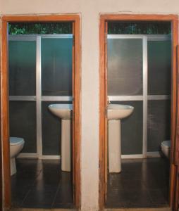 a bathroom with two sinks and two toilets at Jungle River in Ginigathena