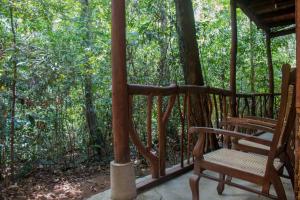 a porch with a rocking chair on a house at Jungle River in Ginigathena