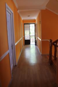 an empty hallway with orange walls and wooden floors at Hotel Kavkasioni in Kvareli