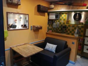a room with a table and a chair and a table and a counter at La Coloniale in Saint Malo