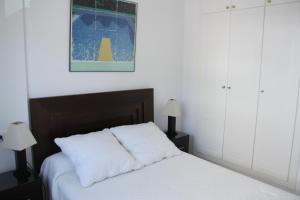 1 dormitorio con 1 cama con 2 almohadas blancas en Ático dúplex 2 linea de playa en La Antilla, en La Antilla