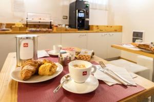 a table with a cup of coffee and pastries on it at Hotel All'Arco in Trieste