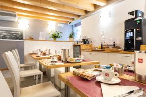 a kitchen with tables and chairs in a room at Hotel All'Arco in Trieste +37 photos