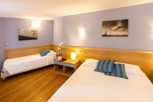 a hotel room with two beds and a table at Hotel All'Arco in Trieste