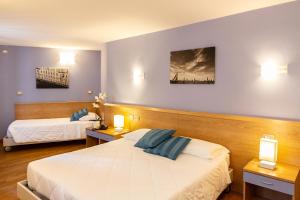 a hotel room with two beds and two lamps at Hotel All'Arco in Trieste