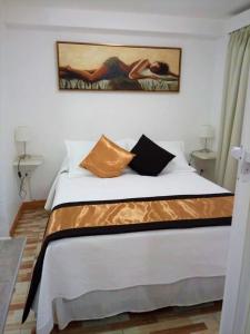 a bedroom with a bed with a painting on the wall at Guest Home Valto & Ziron in Arica