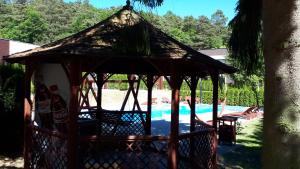 a gazebo with chairs next to a swimming pool at Wisełka Studio in Wisełka +16 photos