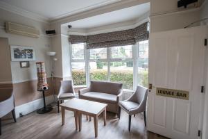 a living room filled with furniture and a window at Corner House Hotel Gatwick in Horley