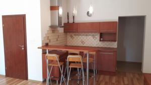 a kitchen with wooden cabinets and a bar with stools at Wisełka Studio in Wisełka