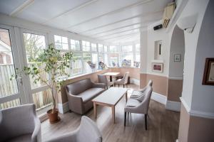 Corner House Hotel Gatwick with Holiday Parking في هورلي: غرفة بها كراسي وطاولة ونوافذ