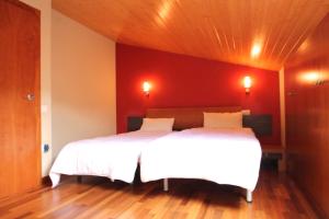 two beds in a bedroom with a red wall at Narcis, Atico en El Tarter, Zona Grandvalira in El Tarter
