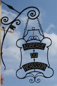 a sign hanging from the side of a building at Auberge du Hérisson in La Chaux-du-Dombief