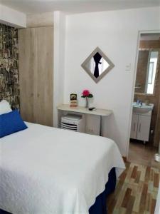 1 dormitorio con cama blanca y lavamanos en Guest Home Valto & Ziron en Arica