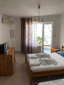 a bedroom with a bed and a television and a window at Family Hotel Sinemoretz in Sinemorets