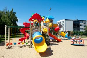 a playground with a slide in the sand at Domki drewniane Zem-Tourist in Pustkowo