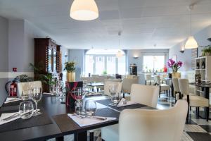 a dining room with a long table and chairs at Logis Hôtel Restaurant du Commerce in Estang