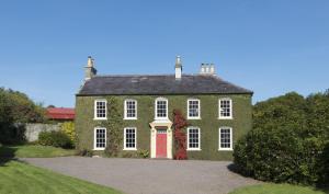 a large green brick house with a red door at Tullymurry House in Newry