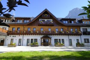 a building with a balcony on top of it at Residence Langes in San Martino di Castrozza