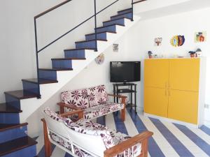 een woonkamer met een trap en een tv bij Casa Azzurra in Alcamo Marina