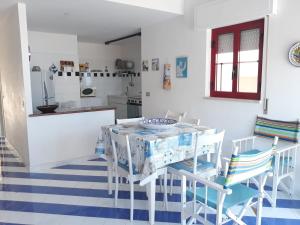 アルカモ・マリーナにあるCasa Azzurraの白いキッチン(テーブル、椅子付)