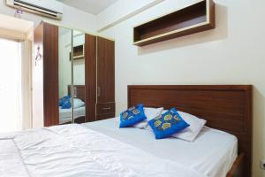 Un dormitorio con una cama con almohadas azules. en Star Apartemen Margonda Residence 2, en Pondokcina