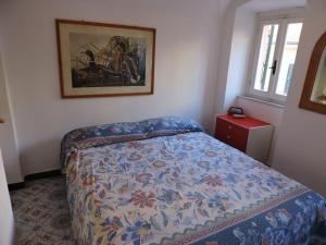 sypialnia z łóżkiem i obrazem na ścianie w obiekcie La Casa nel Borgo w mieście Tellaro