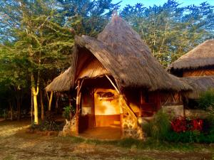 une petite cabane au toit de chaume dans l'établissement Amboseli Eco Camp, à Amboseli